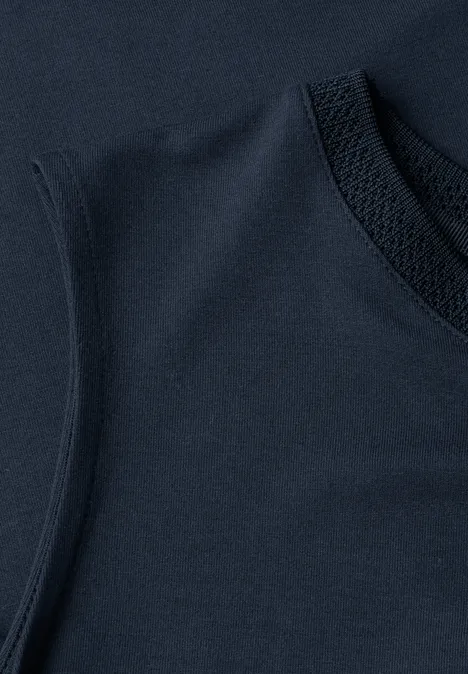 Close-up van een marineblauw mouwloos topje van zachte stof met zichtbare ronde halsnaad