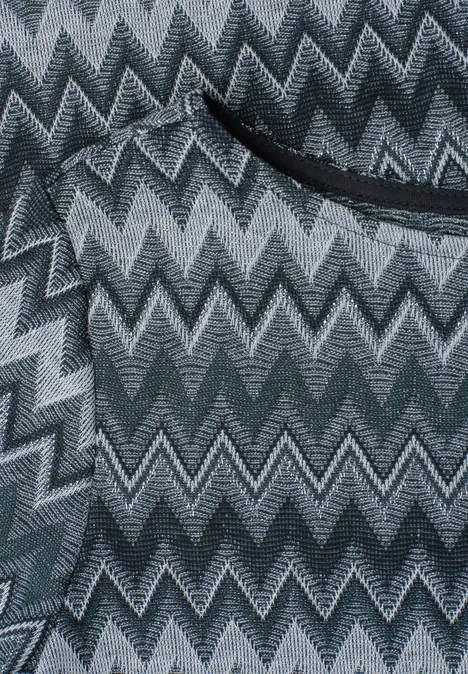 Close-up van een grijze zigzagstof met zwarte zakopening.