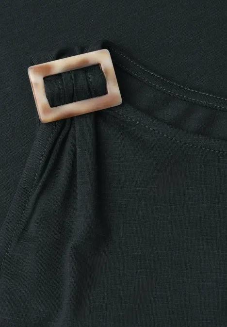 Schwarzes Kleidungsstück mit rechteckiger beige-brauner Schnalle an der Seite