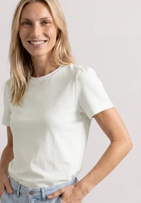 T-Shirt mit gerafftem Ärmel off white Frau in weißem T-Shirt und Jeans steht lässig mit einer Hand in der Tasche.