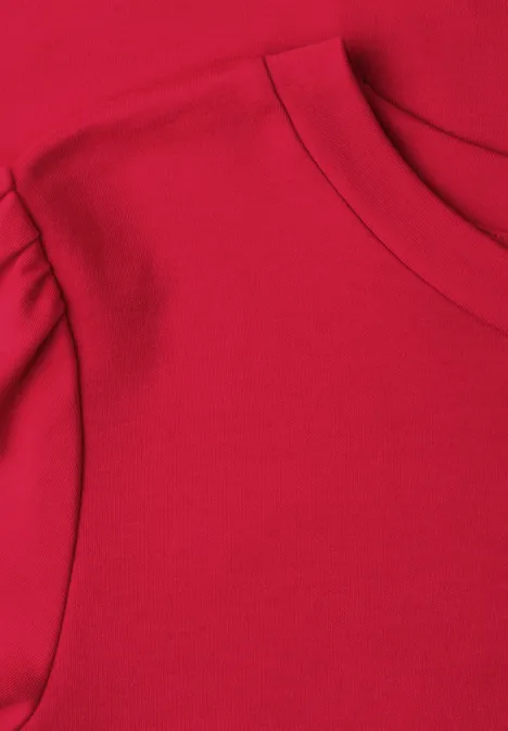 Nahaufnahme eines roten T-Shirts mit Rundhalsausschnitt und überschnittener Schulter