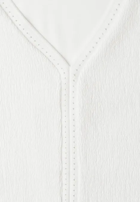 Witte, gestructureerde top met V-hals en fijne opengewerkte rand.