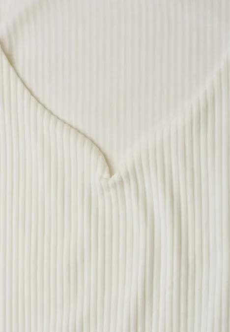 Nahaufnahme eines cremefarbenen, gerippten V-Ausschnitt-Oberteils.