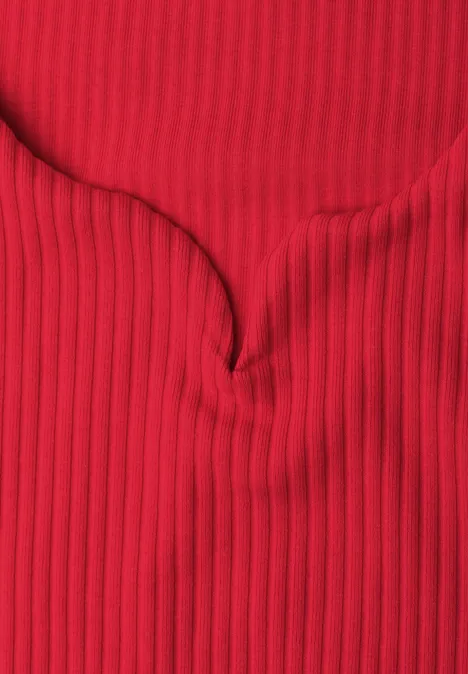 Tissu rouge côtelé à fines stries verticales avec un pli central