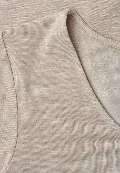 Nahaufnahme eines ärmellosen Beigetops aus weichem Baumwollstoff mit Rundhalsausschnitt.