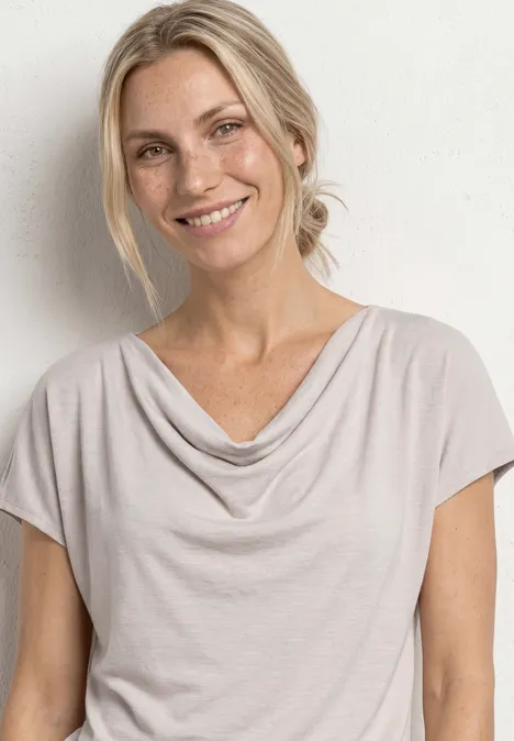 Silk-Look Shirt mit Waterfall-Front clay sand Helle Person mit blondem Haar in lockerem Shirt mit Wasserfallausschnitt vor schlichter weißer Wand.