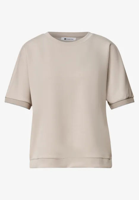 Eenvoudig, kort mouw T-shirt in licht beige, ronde hals en een iets losse pasvorm.