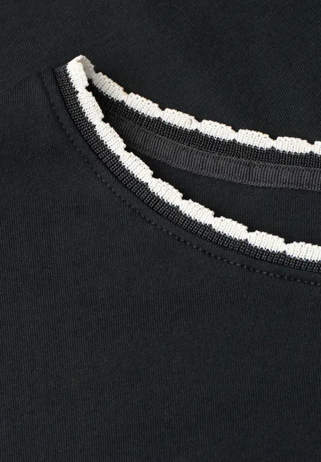 Zwart shirt met ronde hals en witte, gegolfde afwerking.