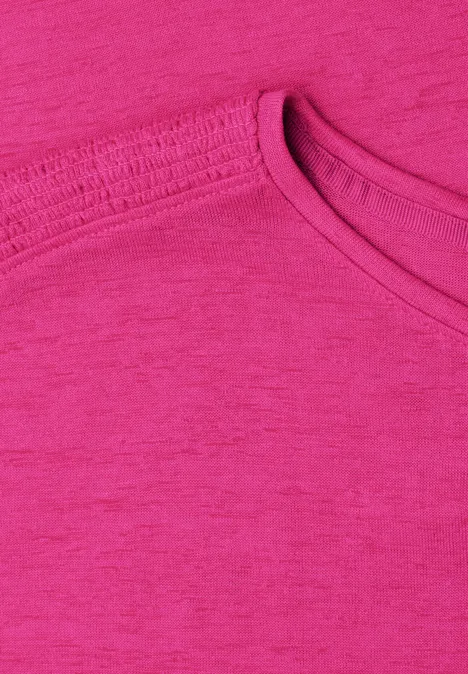 Close-up van een roze T-shirt met ronde hals.