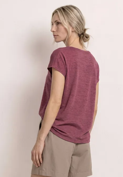 Vrouw gezien van achteren met een bordeaux t-shirt en beige short, blik afgewend.