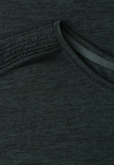 Close-up van een donker sportshirt met schuine halslijn en gemêleerde stof.