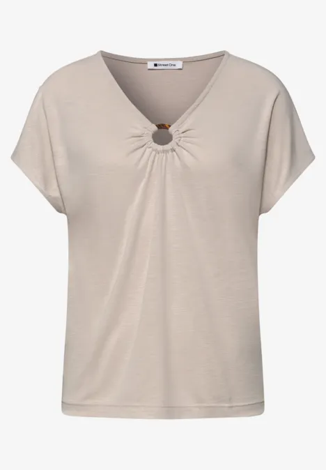 Beige dames T-shirt met V-hals, korte mouwen en decoratieve ring bij de hals.