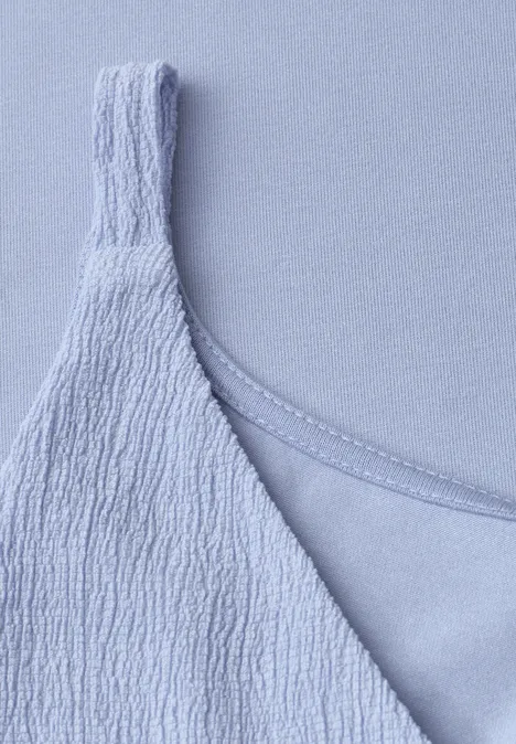 Nahaufnahme eines hellblauen, strukturierten Spaghettiträger-Tops.