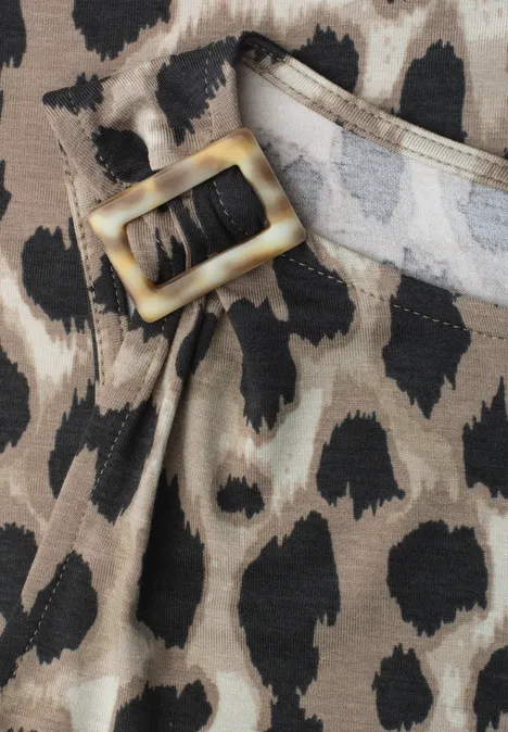 Nahaufnahme eines Gürtels mit goldfarbener Schnalle und Leopardenmuster auf Stoff.