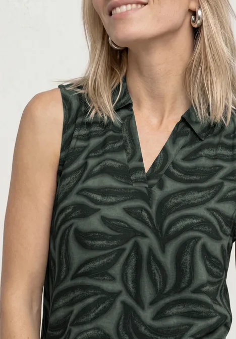 Top mit Kragen und Strukturmix deep bound green Blonde Frau trägt ärmellose dunkelgrüne Bluse mit abstraktem Blattmuster.
