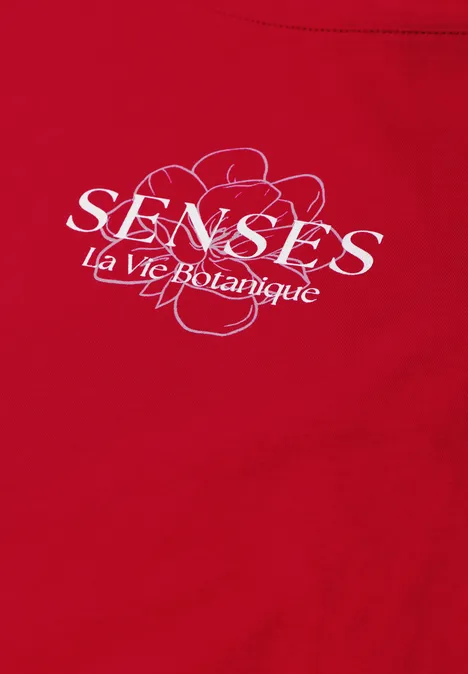 Rood T-shirt met witte tekst 'SENSES La vie Botanique' en gestileerde lijntekening van bloemen.