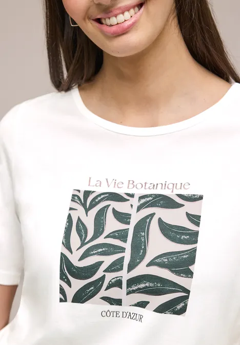 Wit T-shirt met gestileerde bladprint en tekst ‘La Vie Botanique COTE D'AZUR’.