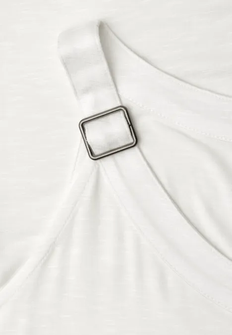 Nahaufnahme eines weißen Trägers mit verstellbarem quadratischem Metallverschluss an Kleidungsstück.