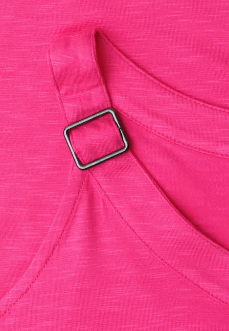 Nahe Aufnahme eines pinkfarbenen Top-Stoffs mit Riemendetail und silberner Schnalle.