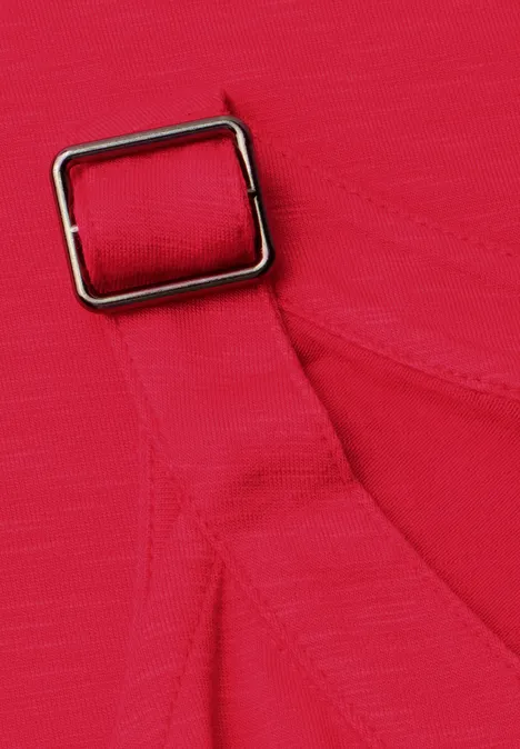 Close-up van een felroze stoffen band met een rechthoekige metalen gesp.