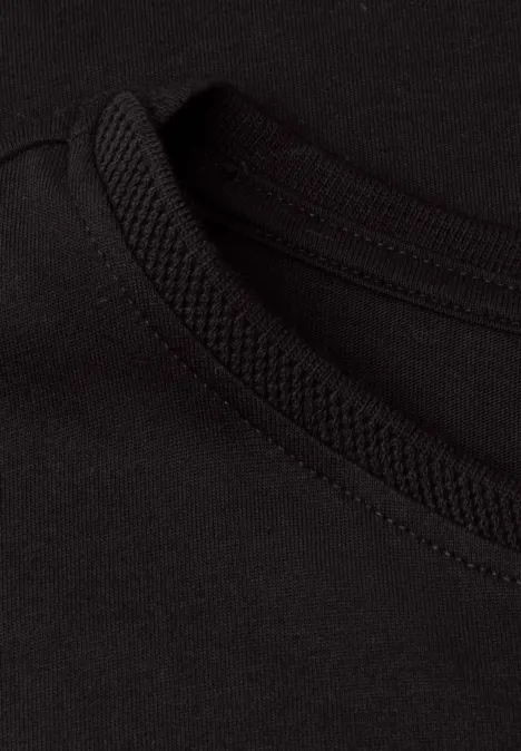 Nahaufnahme eines schwarzen Rundhals-T-Shirts mit sichtbarer, sauber gearbeiteter Naht.