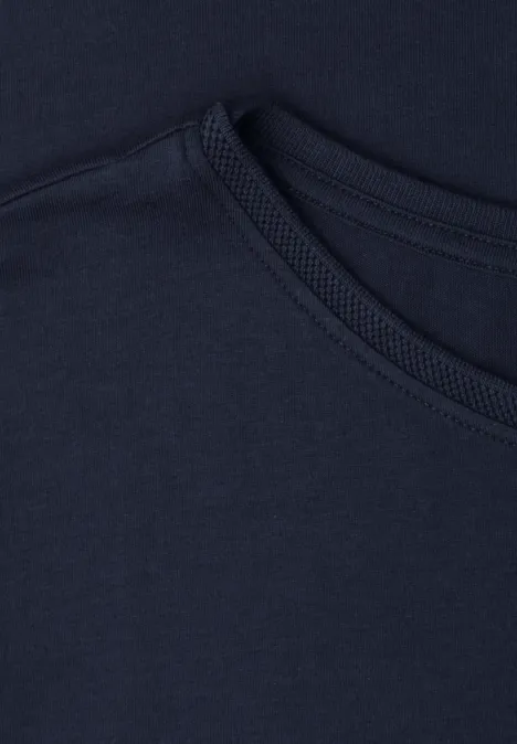 Nahaufnahme von zwei überlappenden dunkelblauen T-Shirt-Kragen aus Baumwollstoff.