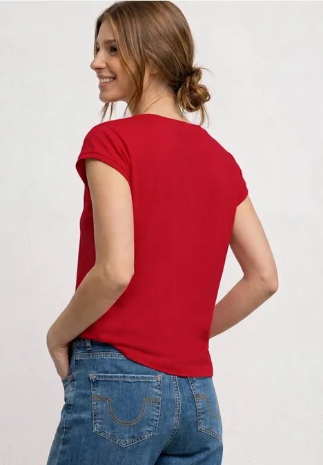 Shirt mit Boatneck und Deko-Detail salsa red Frau in rotem T-Shirt und blauen Jeans, von hinten, mit Händen in den Taschen und zusammengebundenen Haaren.