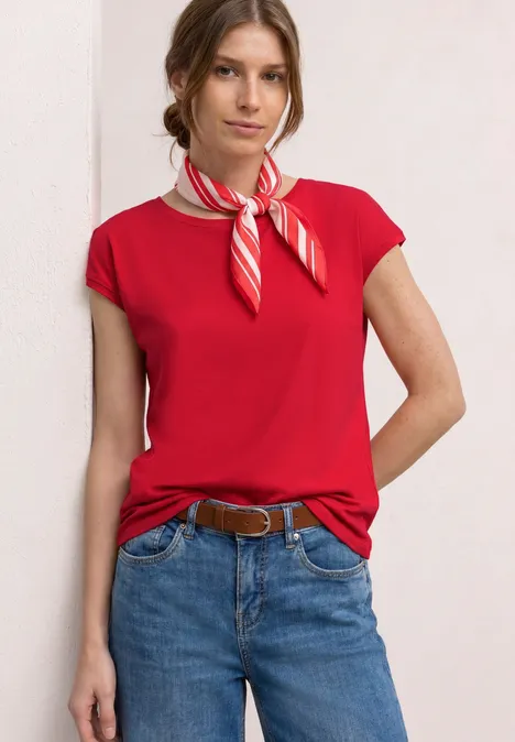 Shirt mit Boatneck und Deko-Detail salsa red Frau in rotem T-Shirt, Jeans, Gürtel und rot-weiß gestreiftem Halstuch.