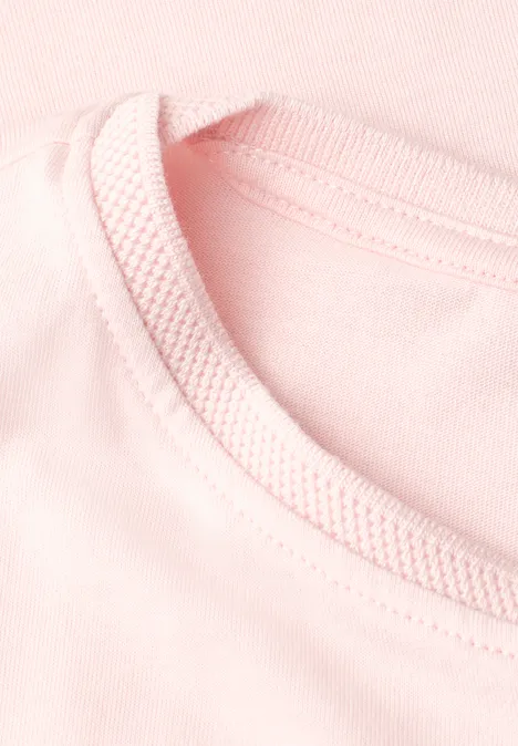Close-up van een roze T-shirt met geribbelde ronde hals.