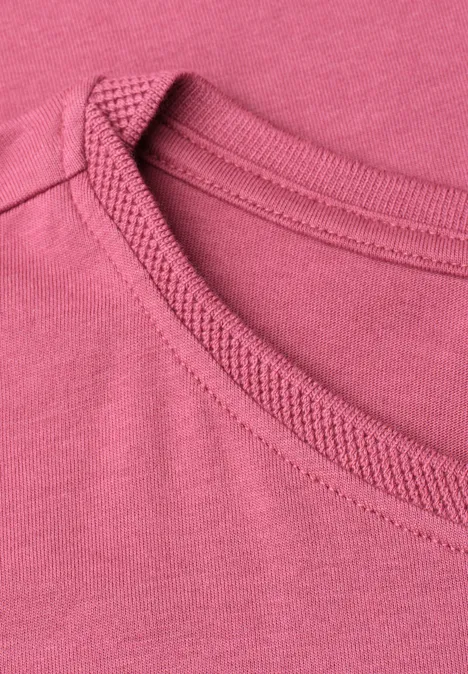 Nahaufnahme eines rosa Rundhalsausschnitts an einem T-Shirt.