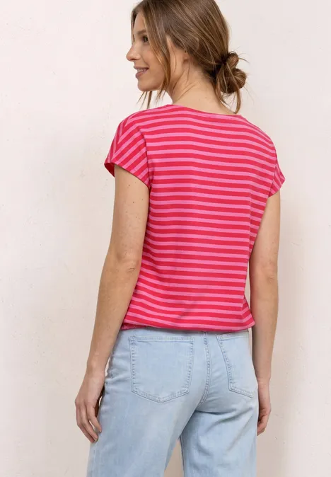 Frau von hinten in rosa-weiß gestreiftem T-Shirt und hellblauen Jeans.