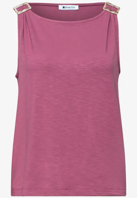 Fuchsia mouwloos top met gouden gespen op de schouders.