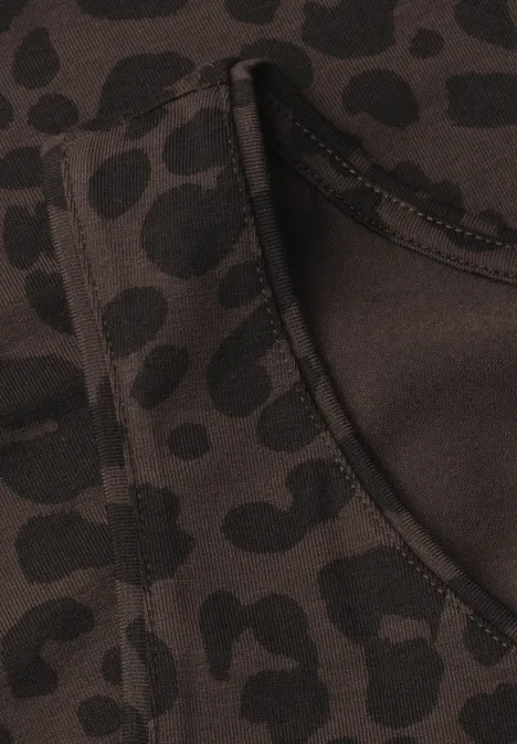 Dunkler Stoff mit schwarzem Leopardenmuster und sichtbarer Tasche mit Naht.