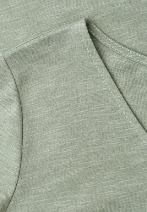 Nahaufnahme eines hellgrünen T-Shirts mit V-Ausschnitt und feiner, melierter Struktur.