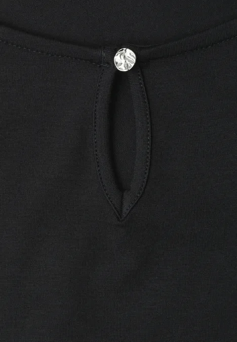 Haut noir avec encolure goutte et petit bouton strass étincelant.