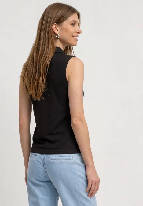 Een vrouw van achteren in een mouwloos zwart topje en lichtblauwe spijkerbroek.