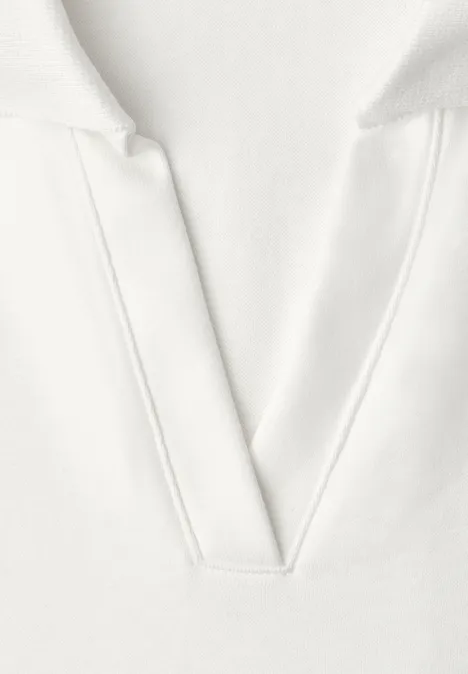 Gros plan d'un t-shirt blanc à col en V en tissu doux.