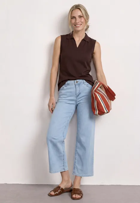 Top in Rippstruktur mit Polokragen espresso brown Frau in dunkelbraunem ärmellosem Oberteil, hellblauen Culotte-Jeans, braunen Sandalen und gestreifter Tasche.