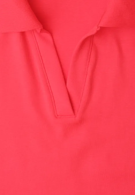 Close-up van een rood poloshirt met V-hals.