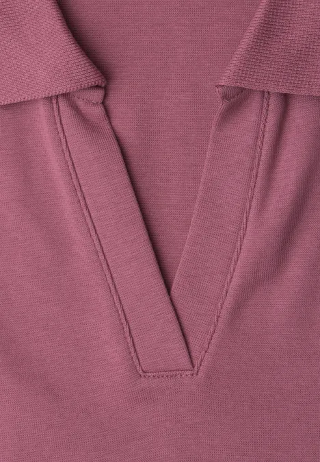 Close-up van een lila gebreide top met V-hals.
