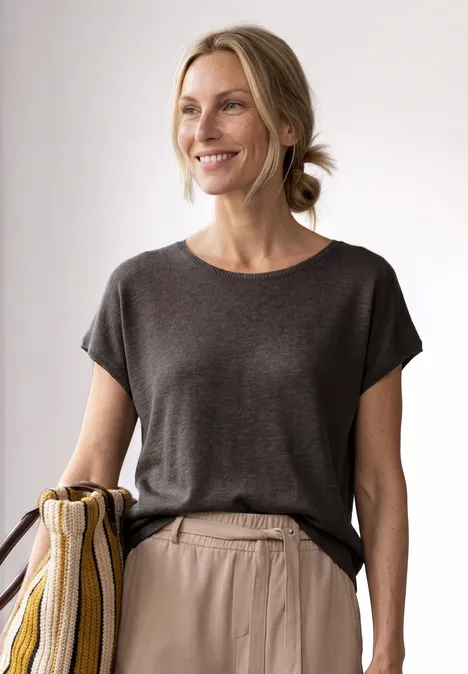 Dropped Shoulder Shirt mit Rundhals espresso brown Frau mit dunkelgrauem T-Shirt und gestreifter Schultertasche, Haare zu einem lockeren Dutt gebunden.