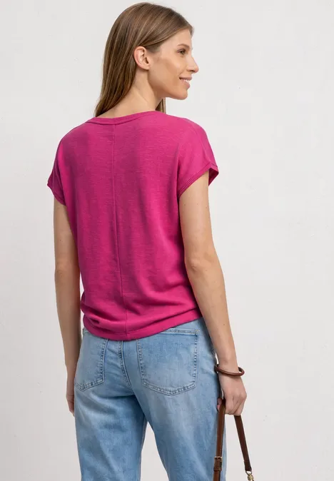 Dropped Shoulder Shirt mit Rundhals magenta dream Eine Frau in pinkem T-Shirt und blauer Jeans mit Tasche, von hinten zu sehen.