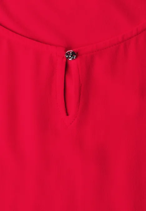 Rood mouwloos top met ronde hals en klein sierknopje voor.