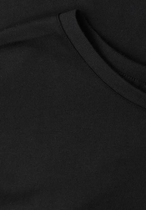 Schwarzer Stoff mit abgerundetem Tascheneingriff, vermutlich eine Brusttasche an einem T-Shirt.