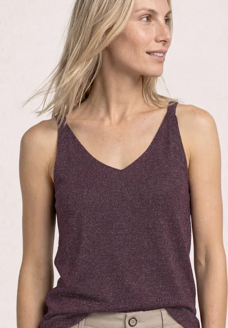Top mit V-Neck und Glitzerdetails rustic rouge Eine Frau trägt ein schimmerndes, weinrotes Top mit V-Ausschnitt und dünnen Trägern.