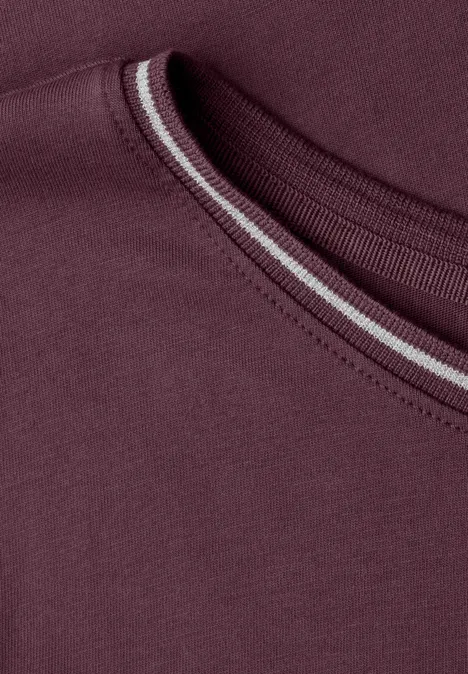 Nahaufnahme eines burgunderfarbenen T-Shirt-Ausschnitts mit dezenter, heller Ziernaht.