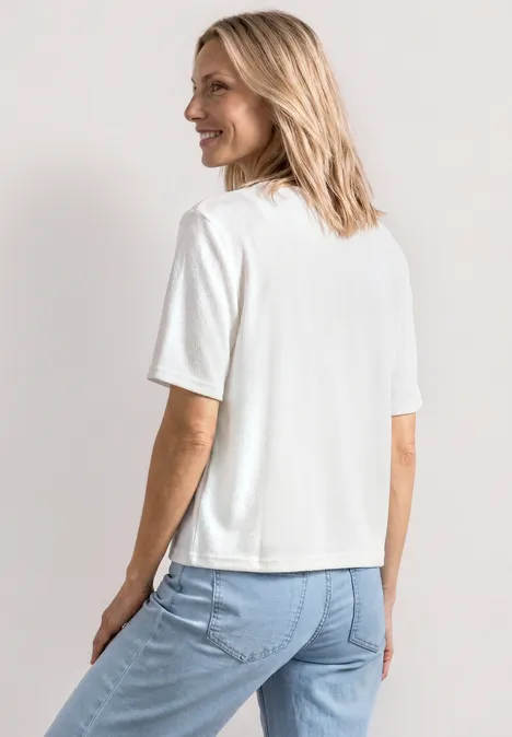 Veste en maille avec rubans off white Femme de dos portant un t-shirt blanc et un jean bleu.