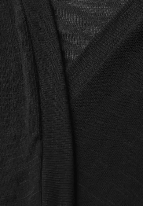 Schwarzer, fein gestrickter Stoff mit überlappenden Partien – vermutlich Teil eines V-Ausschnitt-Pullovers.
