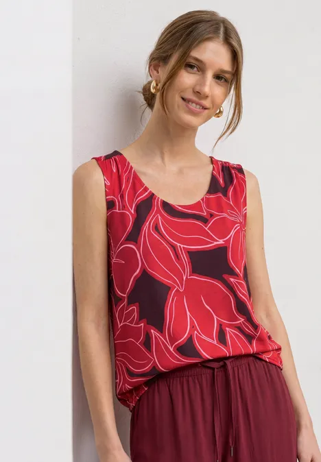 Top mit V-Neck und Elastiksaum salsa red Frau in ärmellosem roten Top mit großem Blattmuster und locker sitzender Hose.