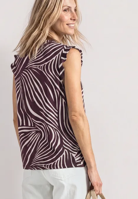 Top mit Strukturmix und Crochet-Details rustic rouge Eine Frau von hinten in einem ärmellosen Top mit Zebrastreifen und einer weißen Hose.